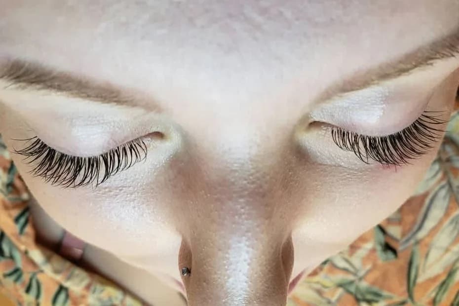 Dark, defined lashes on a client's closed eyes, close up